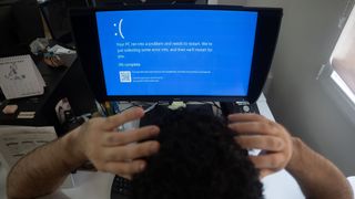 An office worker has a "Blue Screen of Death" error on their Windows PC.