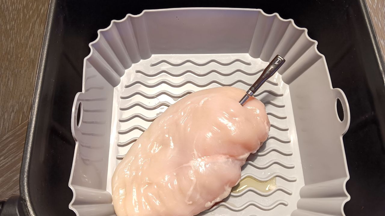 CHEF iQ thermometer probe in raw chicken breast