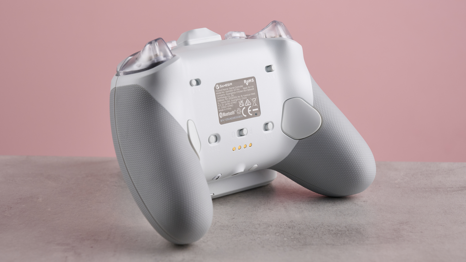 Rear three-quarter view of GameSir G7 Pro, on desk with pink background
