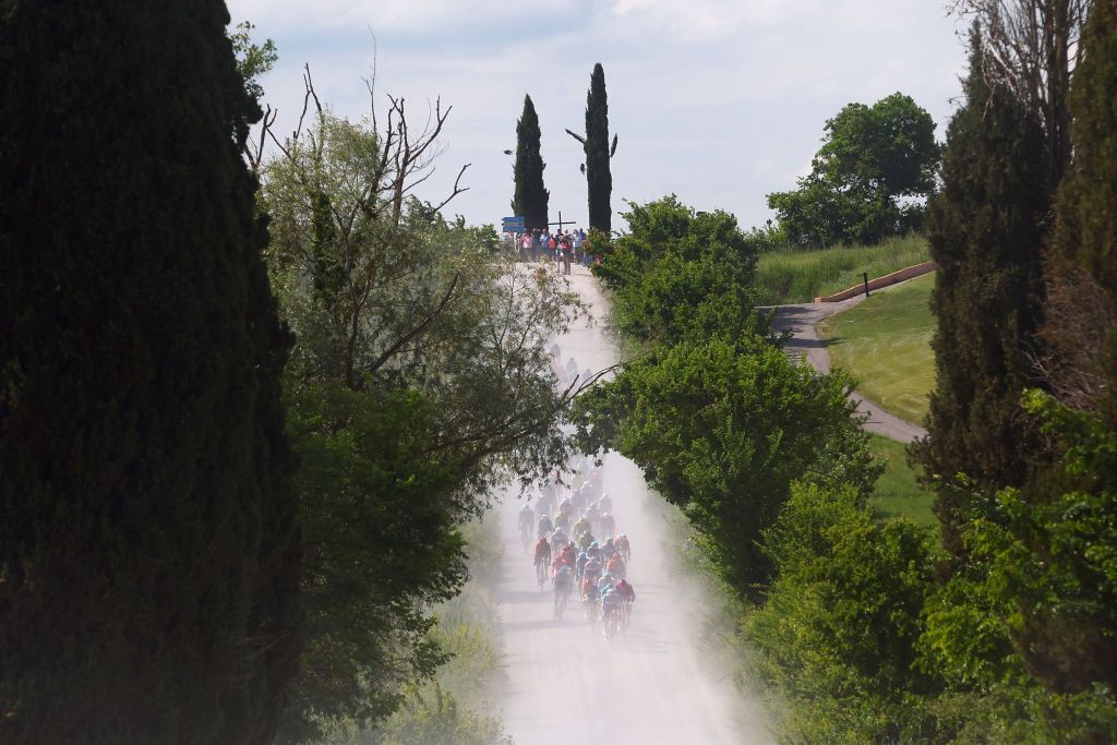 The pack rides on white roads of Tuscany during the 6th stage of the 107th Giro d'Italia cycling race, 180 km between Torre del lago Puccini and Rapolano Terme, on May 9, 2024. (Photo by Luca Bettini / AFP)