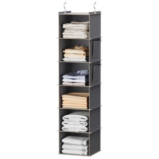 A grey hanging closet organizer with folded clothes and two hooks