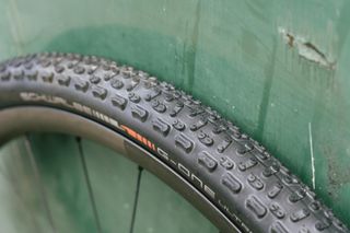 A black gravel tyre against a green wall