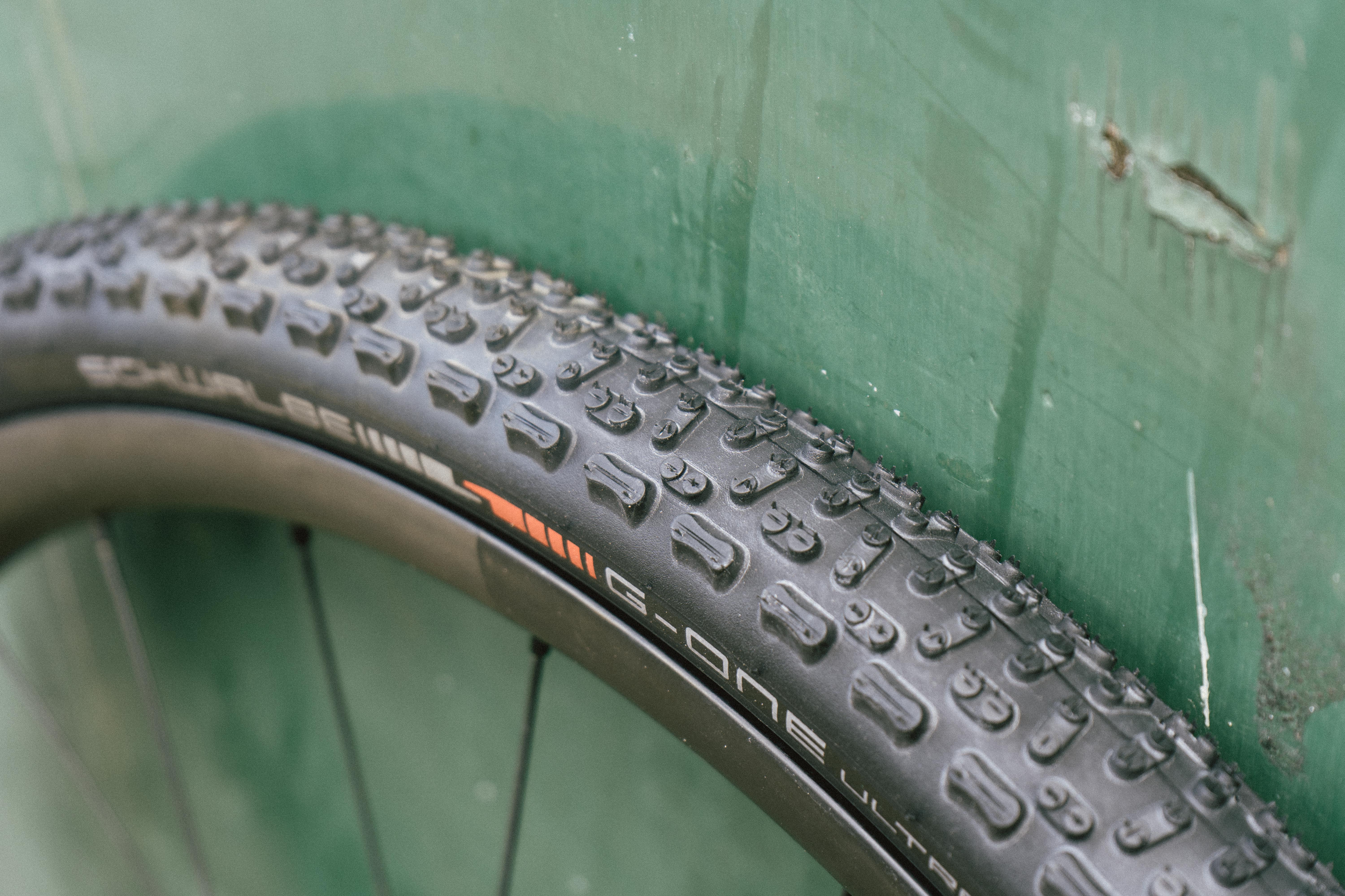 A black gravel tyre against a green wall