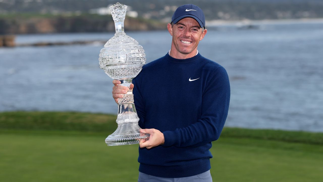 Photo of Rory McIlroy holding the pebble beach trophy
