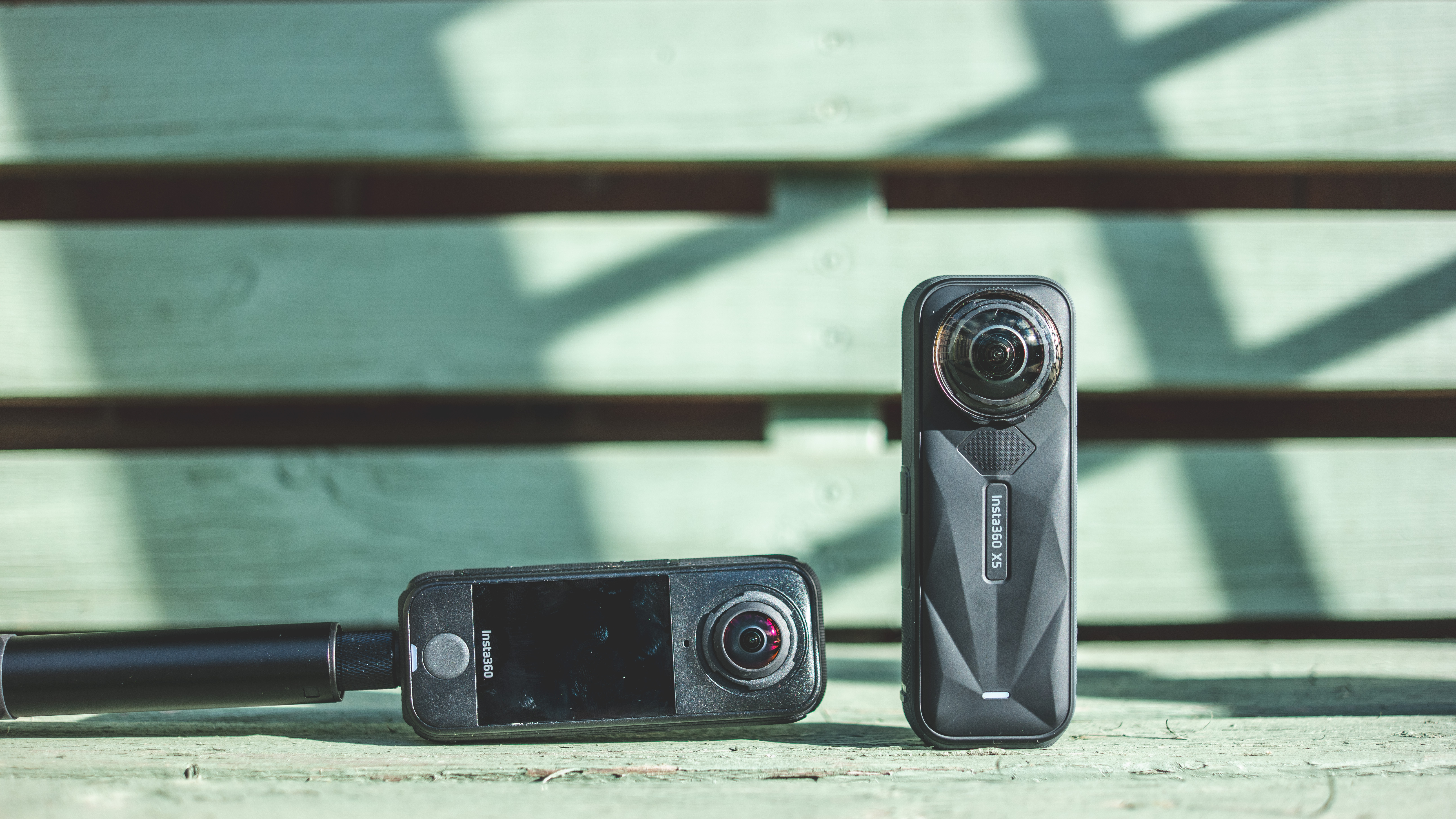 The Insta360 X5 and X4 Air cameras side-by-side in natural sunlight