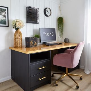 white home office with a black desk and pink office chair and a large desktop computer