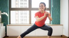 Woman performing side lunge in domestic setting