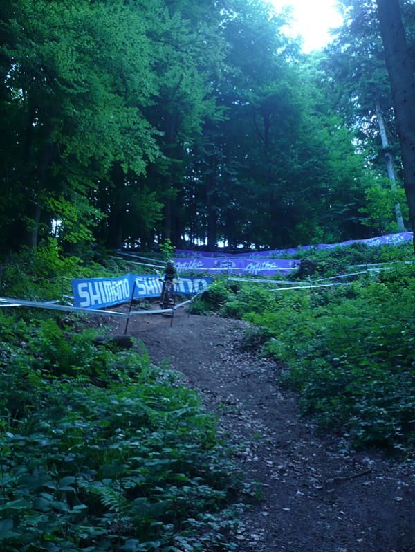 A rider descends some twisty singletrack toward the North Shore drop