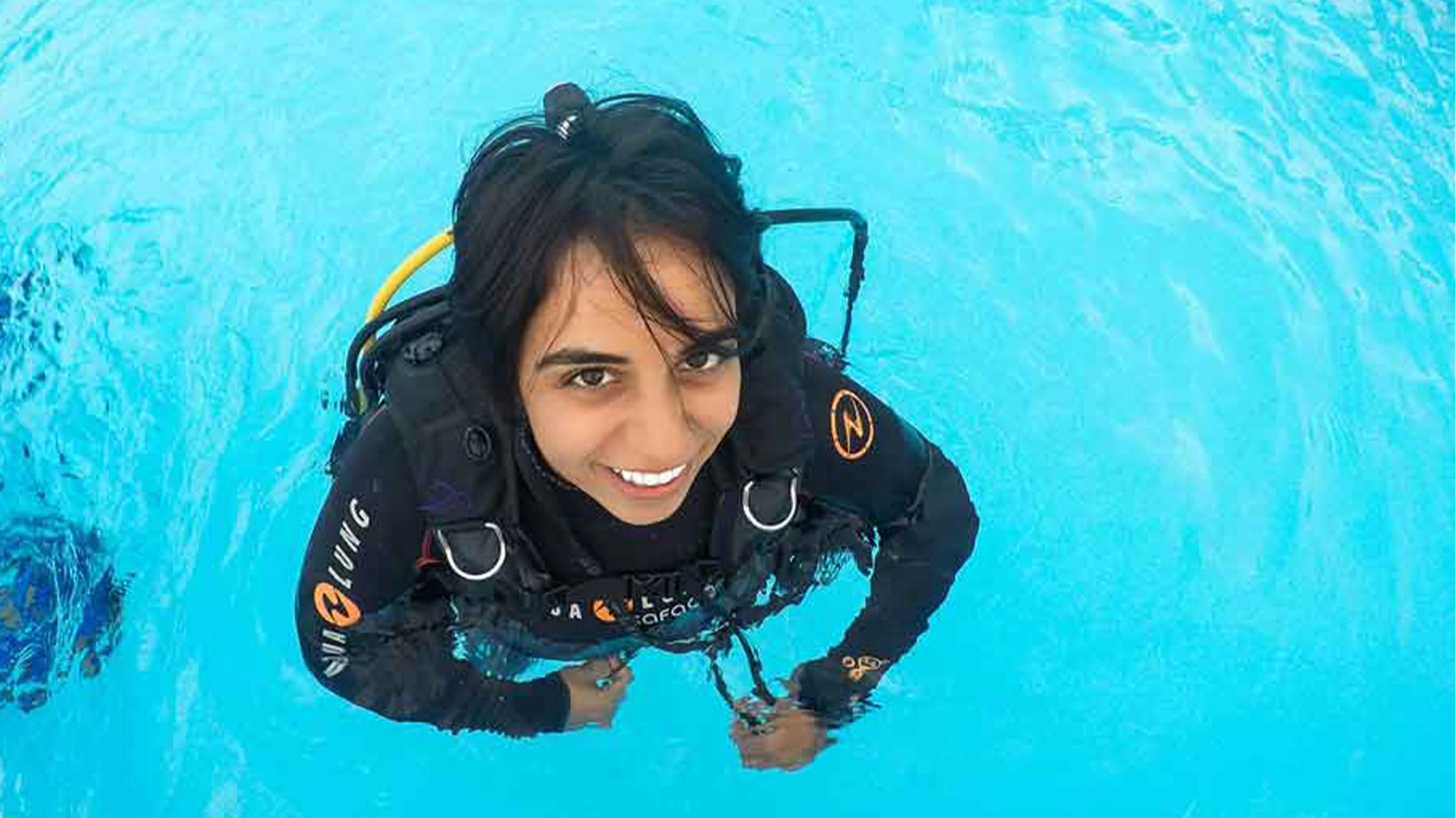 Portrait of Nadia Aly in water and wearing dive gear.