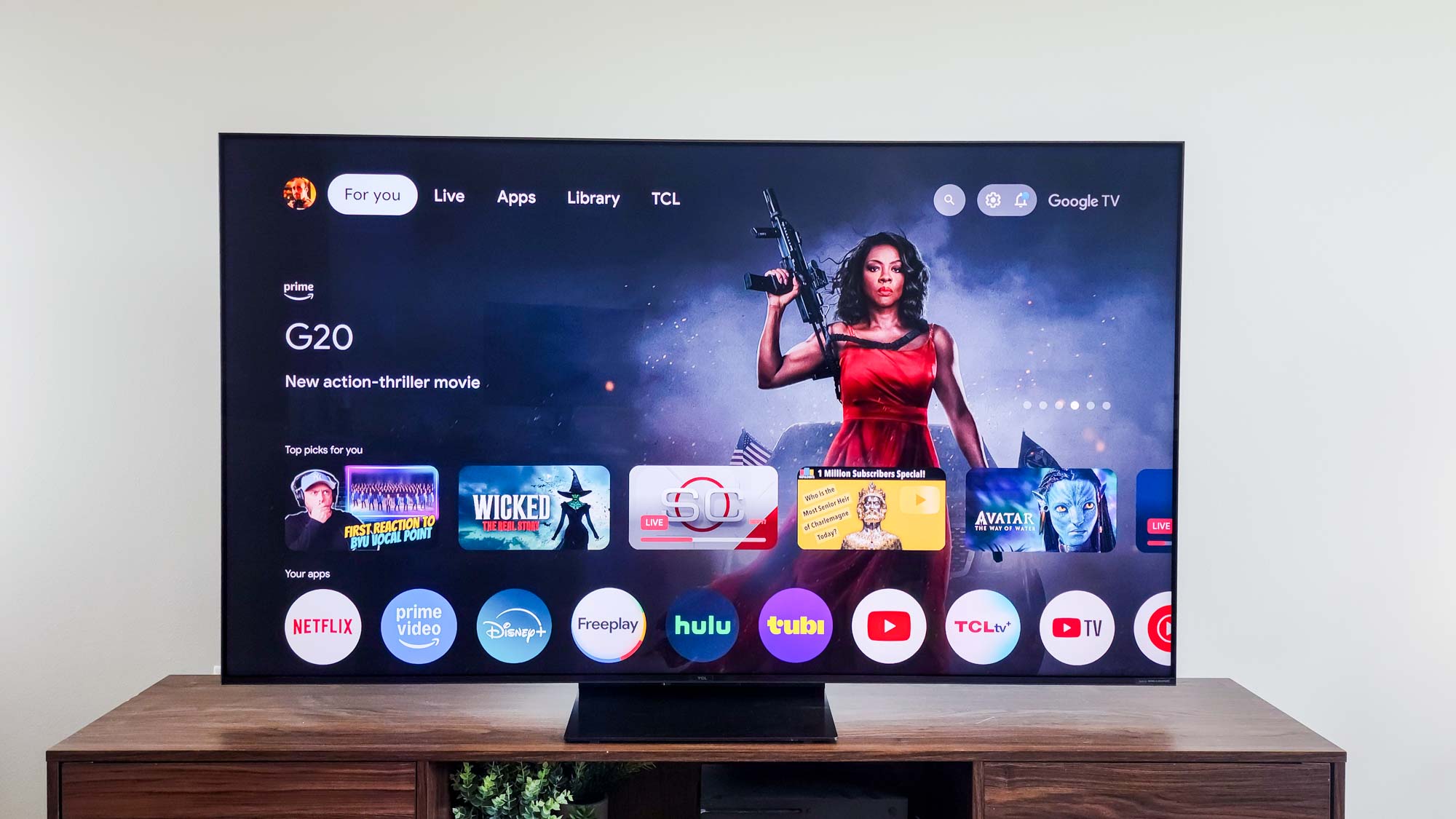 A TCL QM7K QD-Mini LED TV on a side table