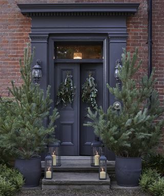 Outdoor Christmas trees, lanterns and wreaths on front door