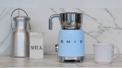 One of the best milk frothers on the market, Smeg milk frother in pastel blue on a marble countertop