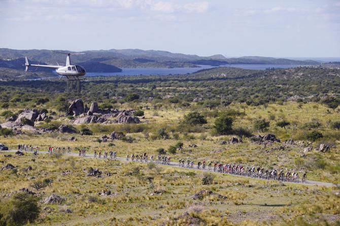The peloton strings out under the pace