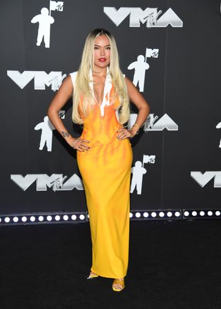 Karol G trägt ein gelbes Kleid auf dem roten Teppich der VMA 2024