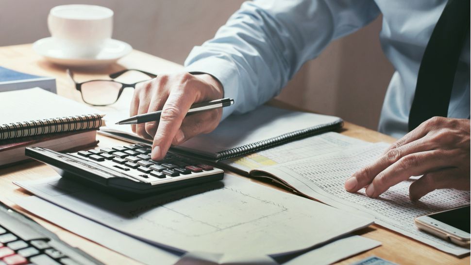 businessman working on desk office with using a calculator to calculate the numbers, finance accounting concept