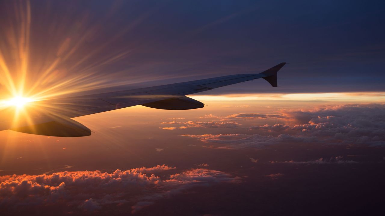 An airplane in the sky, seen from a window inside. 