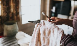 Image of a person in a striped shirt cleaning silverware with a textured cloth