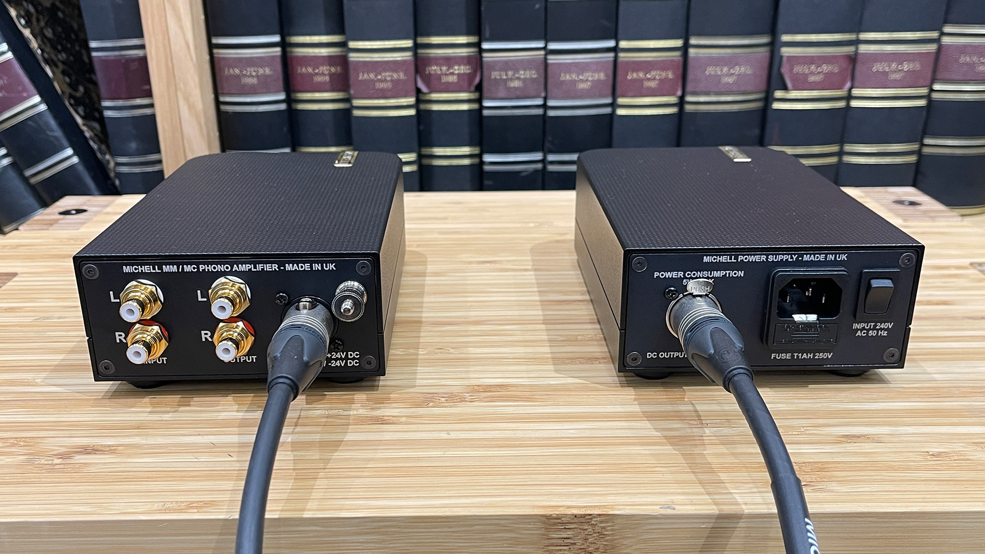 Michell Apollo phono stage on wooden hi-fi rack next to Muse power supply, rear of units showing connections