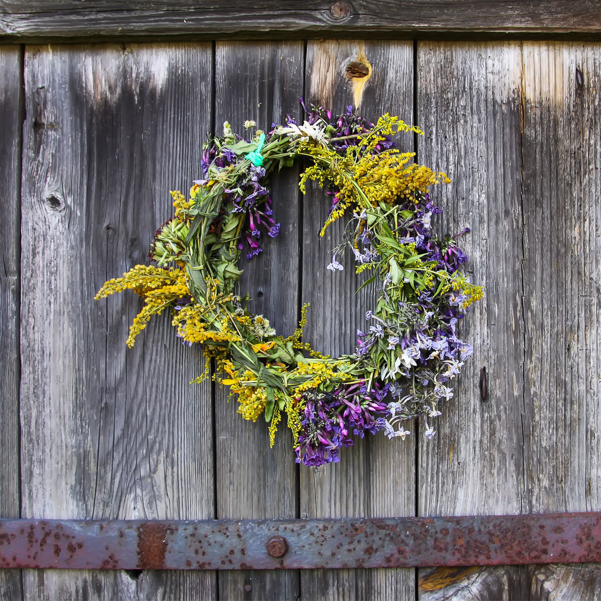 Flower wreath hanging on wooden fence