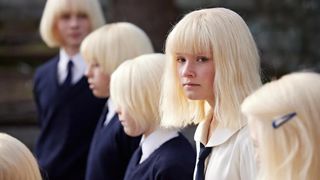 A still from the tv show The Clearing of several child characters with very light blonde hair dressed in school uniform
