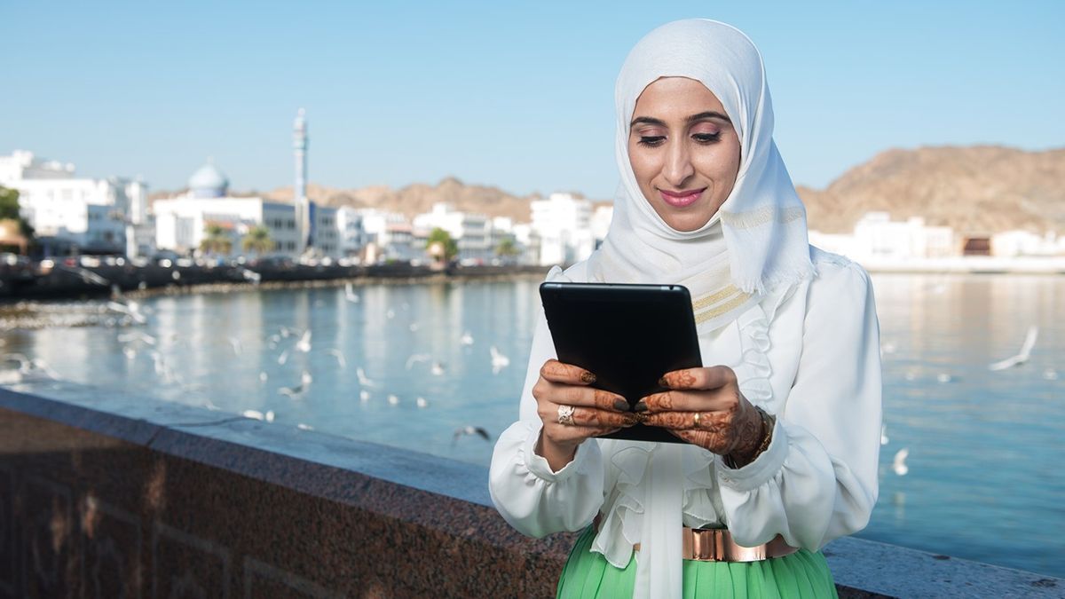 Woman in Oman looking at a tablet.