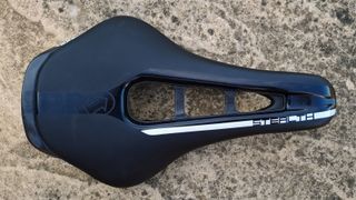 A close up of the Pro Stealth Carbon Saddle on a stone floor