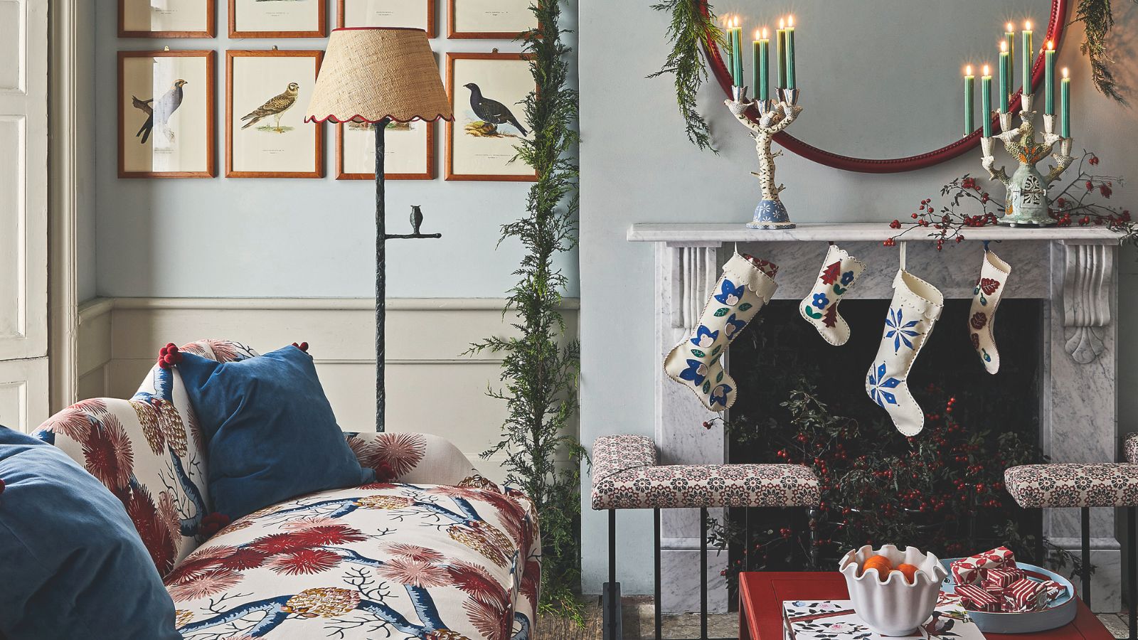 Marble fireplace with blue and white felt stockings and white candelabras with green taper candles