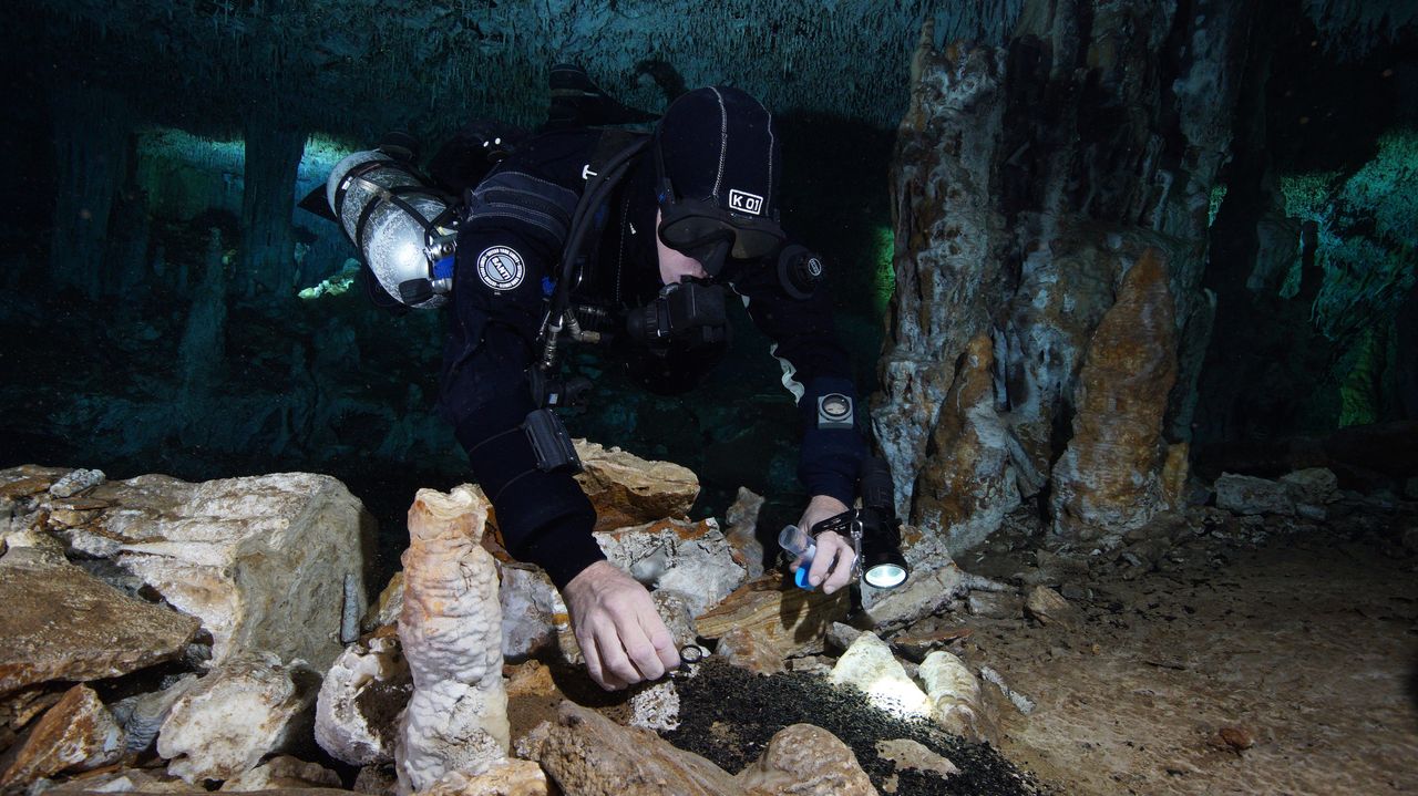 A CINDAQ diver collects charcoal samples in the oldest ochre mine ever discovered in the Americas. The charcoal likely came from wood burned to light the cave for the ancient miners. By looking at the charcoal under a scanning electron microscope, the scientists could tell that it came from a local tree that would have been good for torch wood.