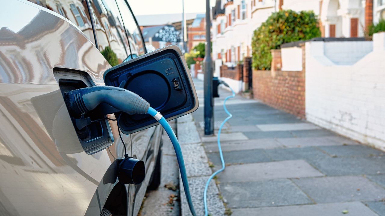 An electric car charges on a sunny day on a London street. 