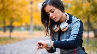 Woman checking sports watch in park