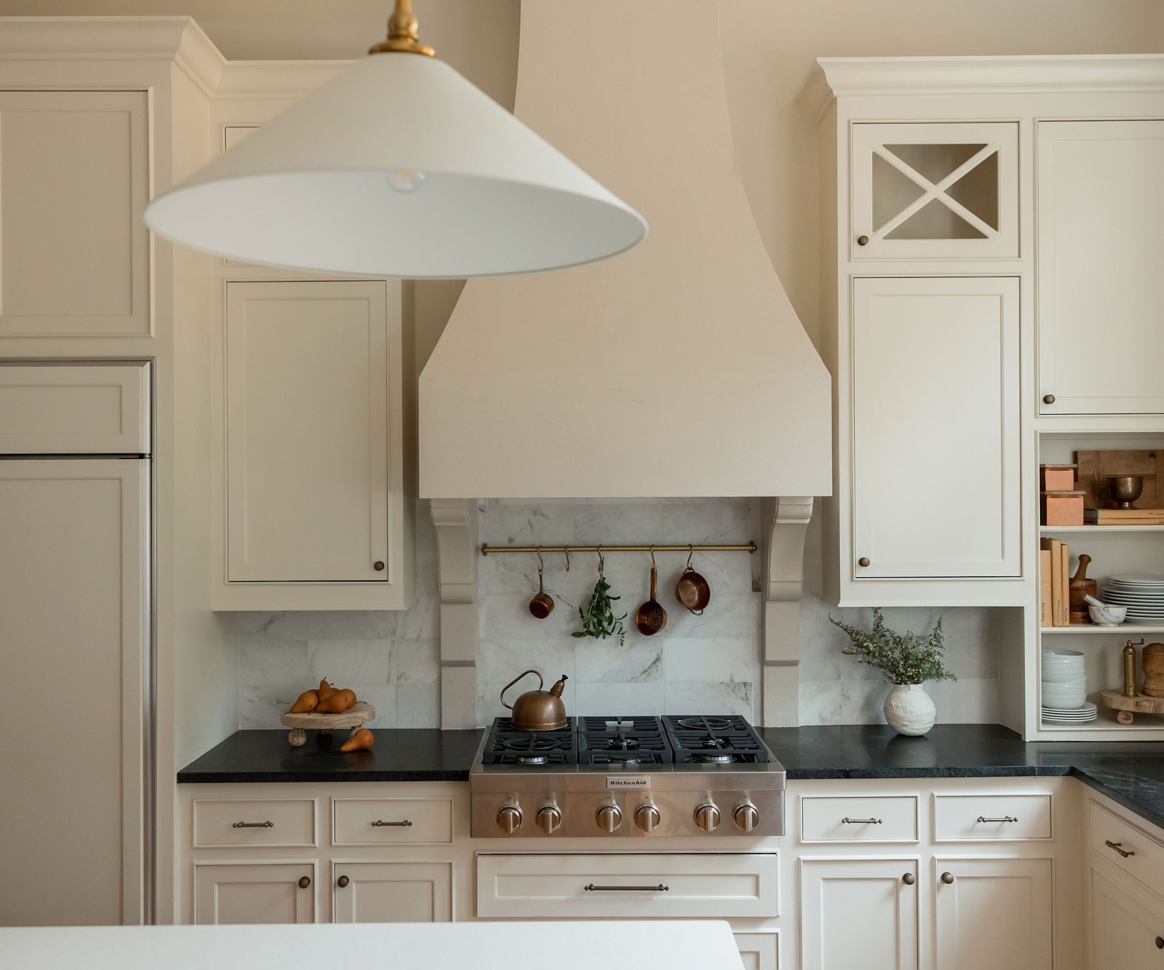 traditional kitchen with warm white cabinets and black countertops
