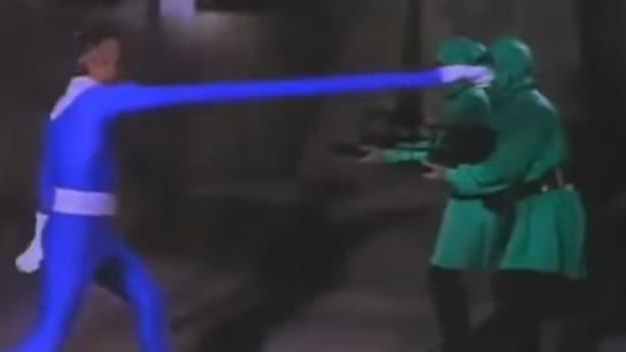a man in a bright blue spandex suit punches a man in a green robe with a long stretchy arm