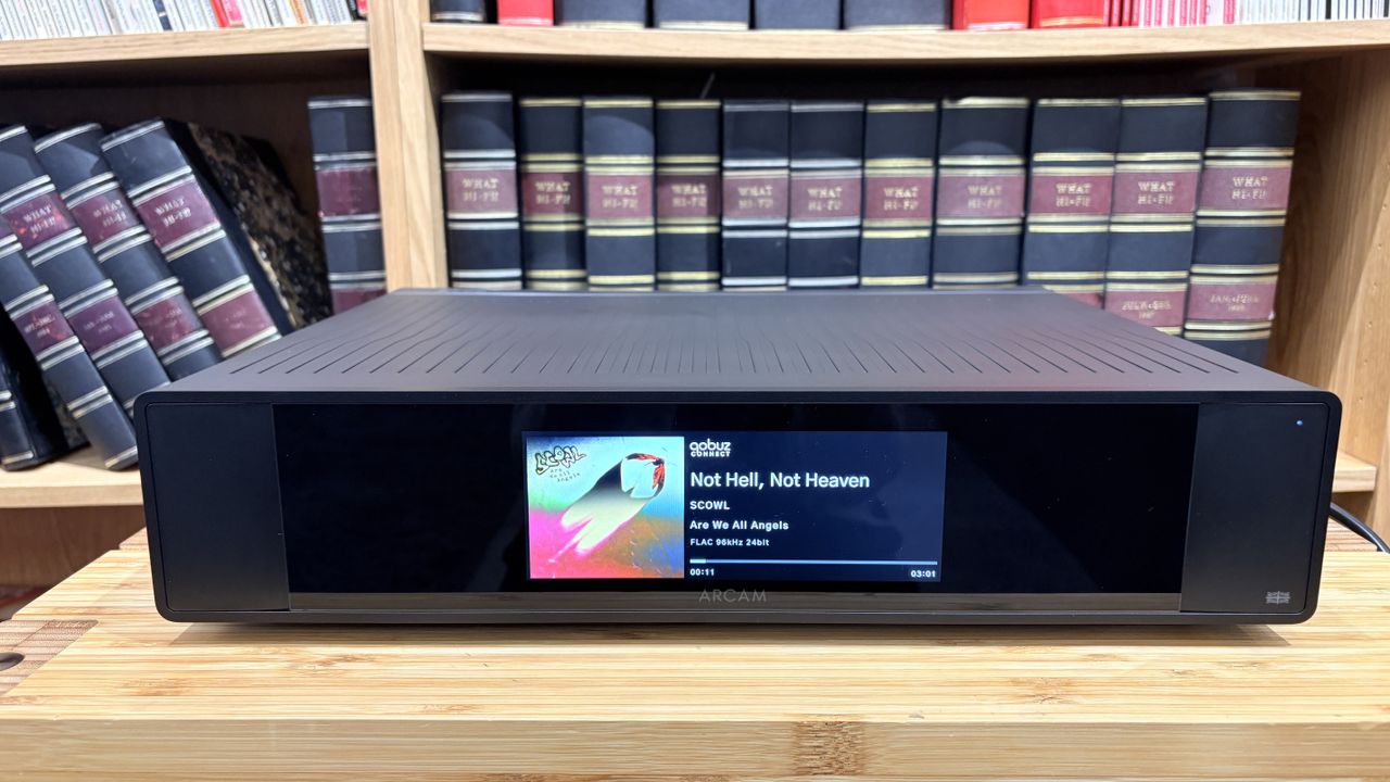 Arcam ST25 music streamer on wooden rack with bookshelf behind it