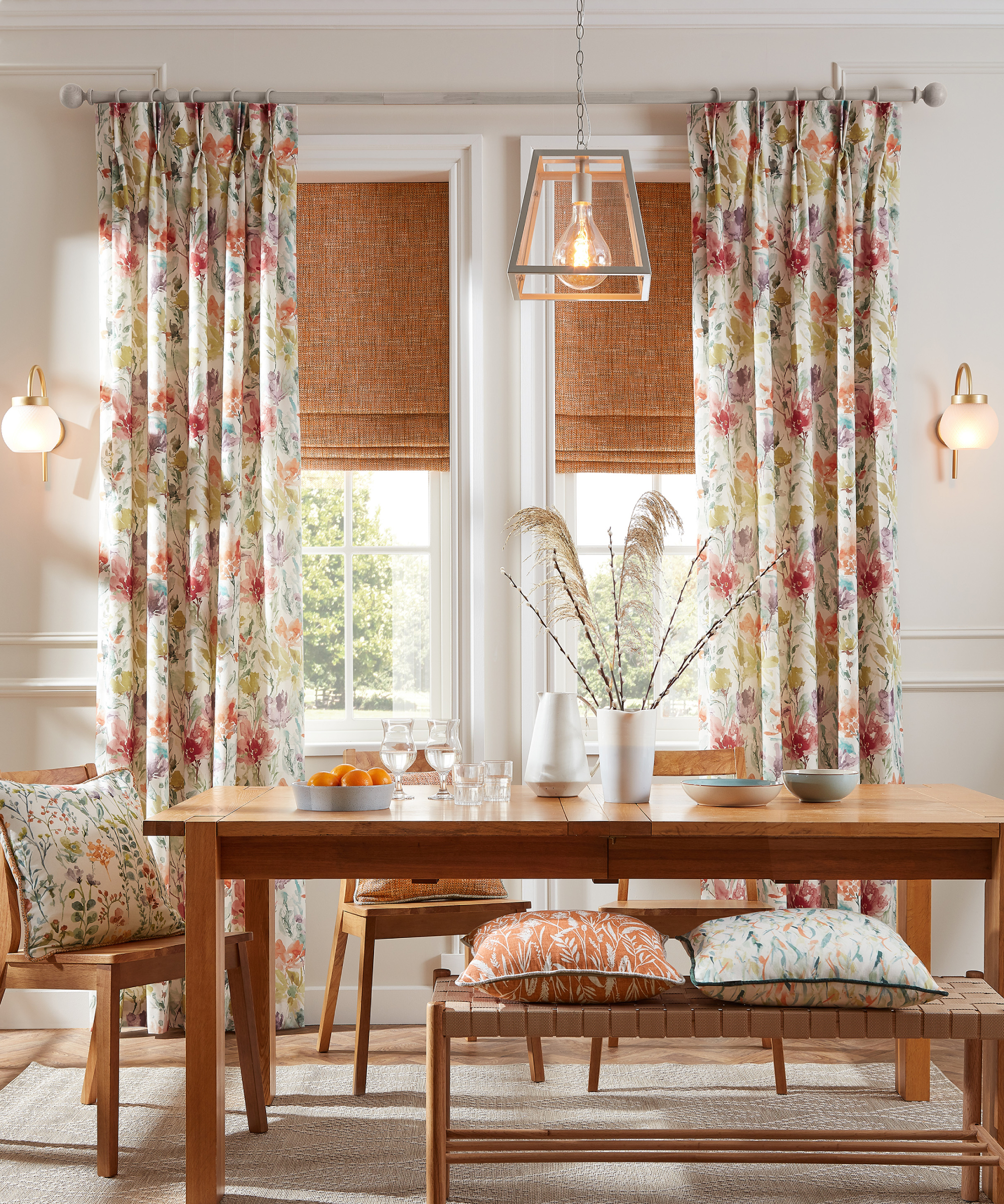 dining room with wooden table and benches, floral cushions and curtains, blinds, pendant and wall lights