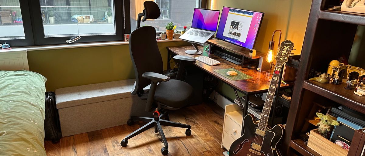 The Herman Miller x Logitech G Vantum gaming chair in a bedroom office with wooden floor and desk.