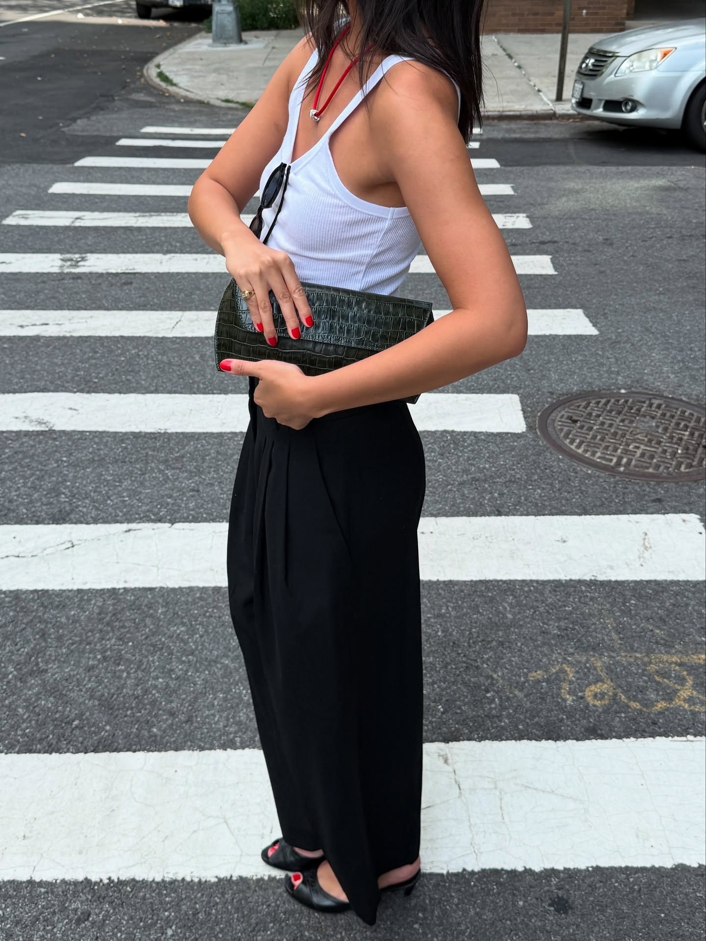dated-summer-shoe-trends-2026: Mimi Nguyes wears a white tank top, black trousers and peep toe shoes