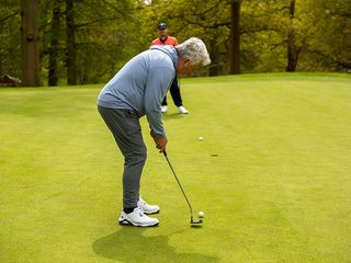 Jezz Elwood hitting a putt on the green at Brocket Hall Golf Club