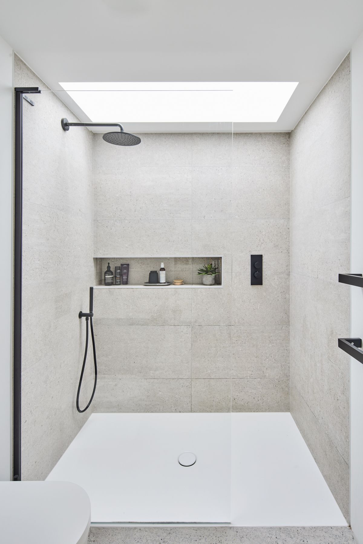 A white minimalist bathroom with a walk in shower
