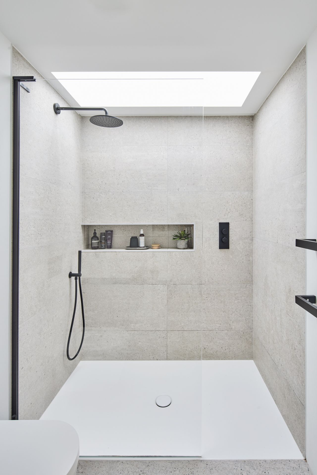 A white minimalist bathroom with a walk in shower