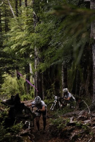Two teammates trudge through the forest
