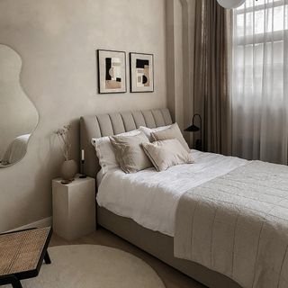 bedroom with bed cushions and photo frame on wall