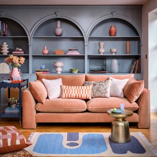 Sofology The Ziggy 3 Seater in a peach shade in a living room with a built-in bookcase with arches in blue