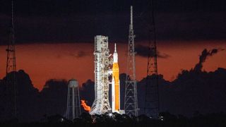 artemis 1 rocket on launch pad backdropped by orange sky