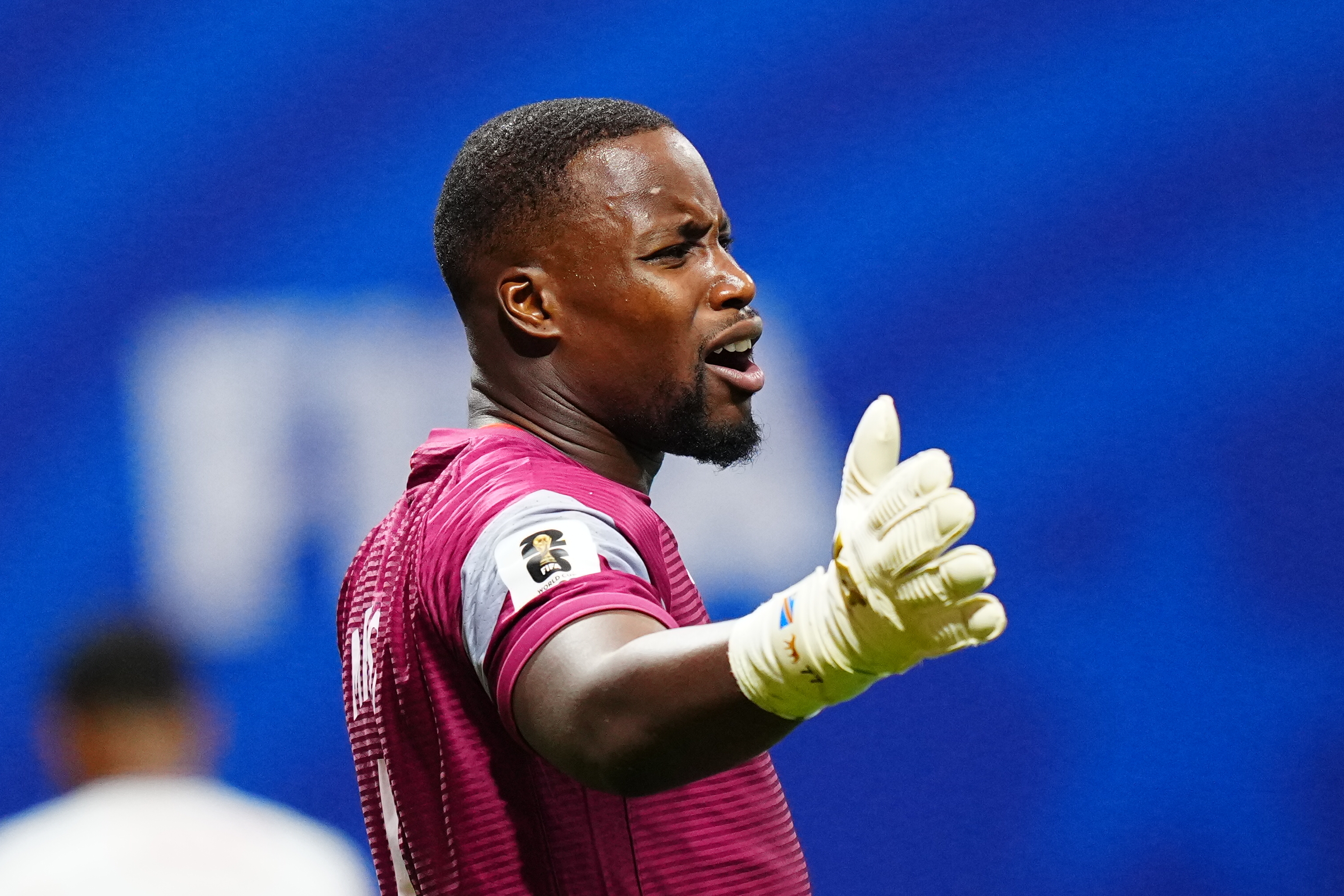 Lionel Mpasi Nzau with his arms open, side profile.