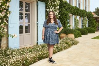 Laura wearing a blue floral dress and converse shoes,