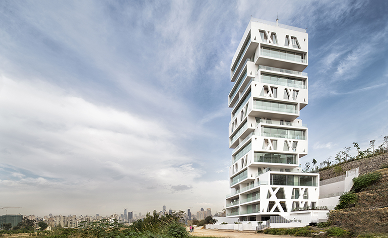 The Cube by Orange Architects, rises majestically above its surroundings like an asymmetrical urban lighthouse