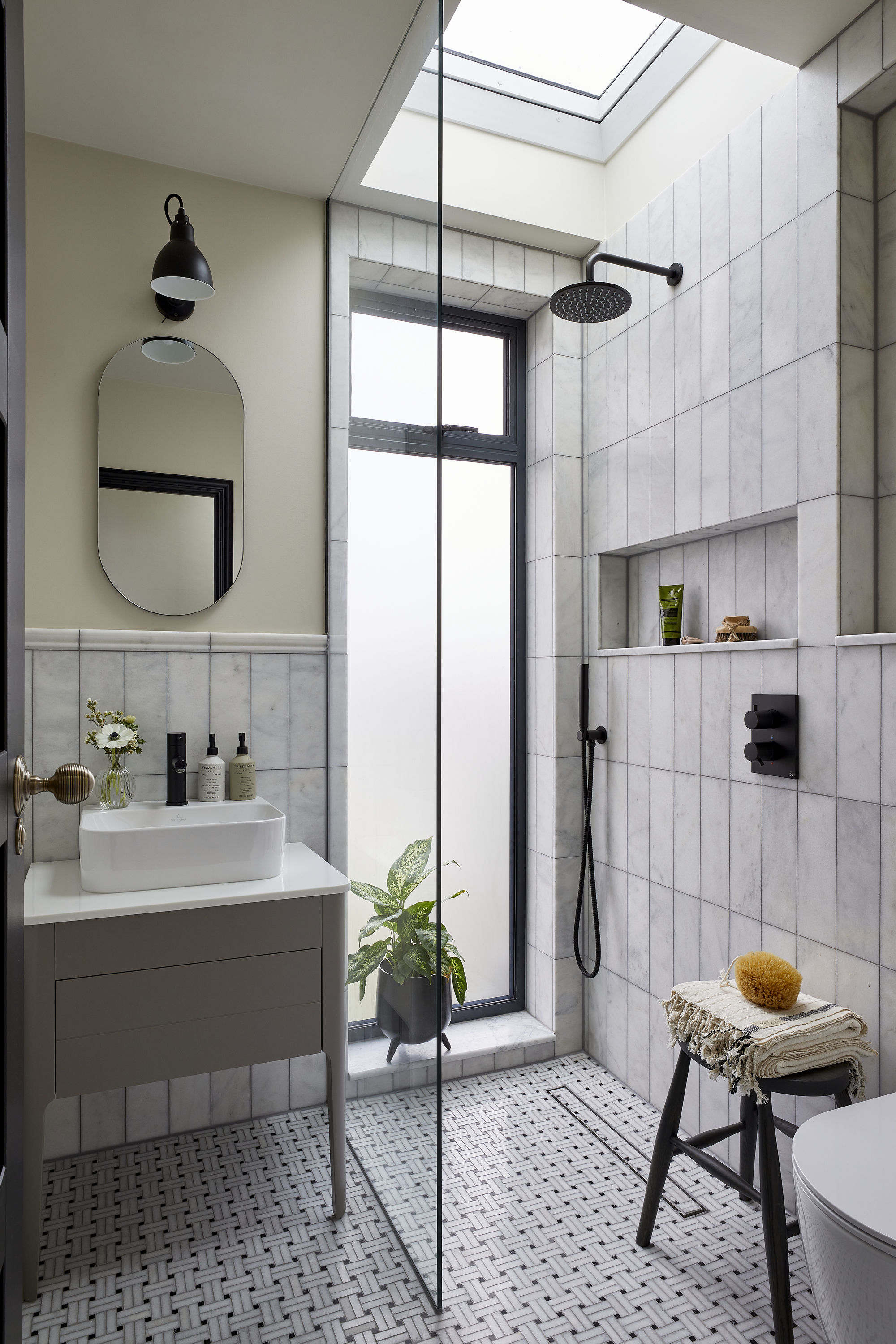 A bathroom with walk-in shower, tiled walls, and patterned flooring