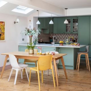 Green coloured kitchen with dining area and table