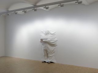 The white wall becomes a white sheet convincingly