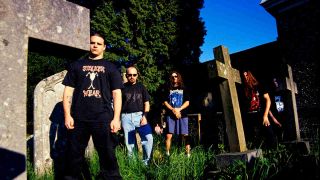 Cannibal Corpse posing for a photograph in a graveyard